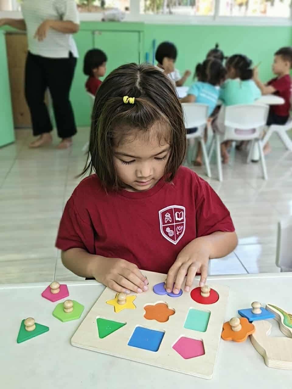 A girl deep in a puzzle at the long table